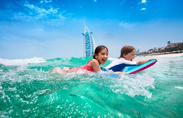Deux enfants surfant sur une vague à Dubai