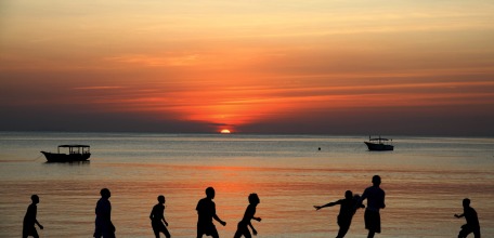 Enfants jouant sur une plage de la côte Sud de Zanzibar au couché du soleil